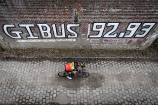 Wout van Aert rides past a tribute to Gilbert Duclos-Lassalle, winner of Paris-Roubaix in 1992 and 1993