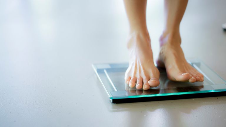 Woman stepping onto a set of the best bathroom scales