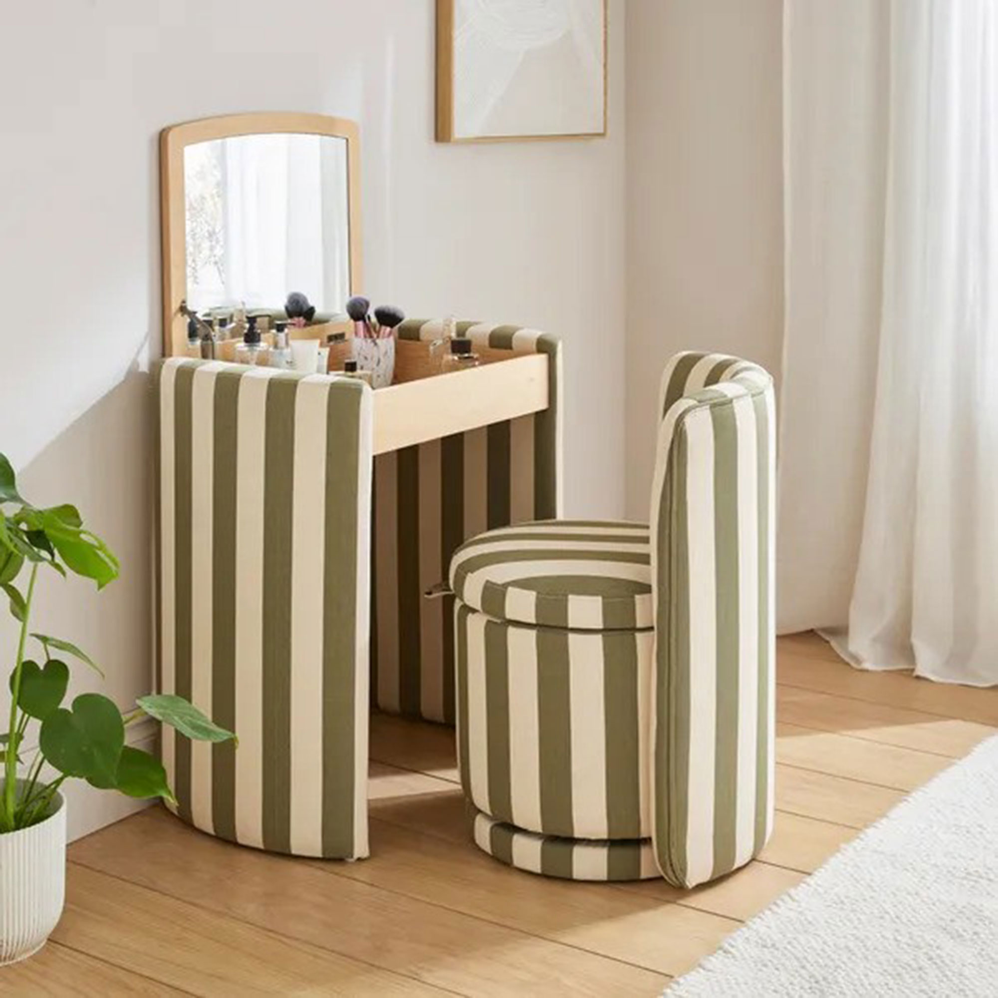 Dressing table in striped fabric in a white bedroom with the lid open and the chair pulled out
