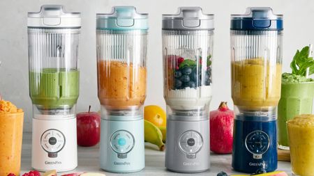 Four GreenPan Spin & Go blenders in pink, blue, grey , and navy, surrounded by fresh fruit 