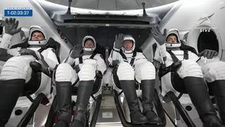 SpaceX Crew-6 astronauts wave in their Crew Dragon Endeavour seats.