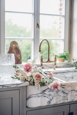 marble sink with flowers in kitchen