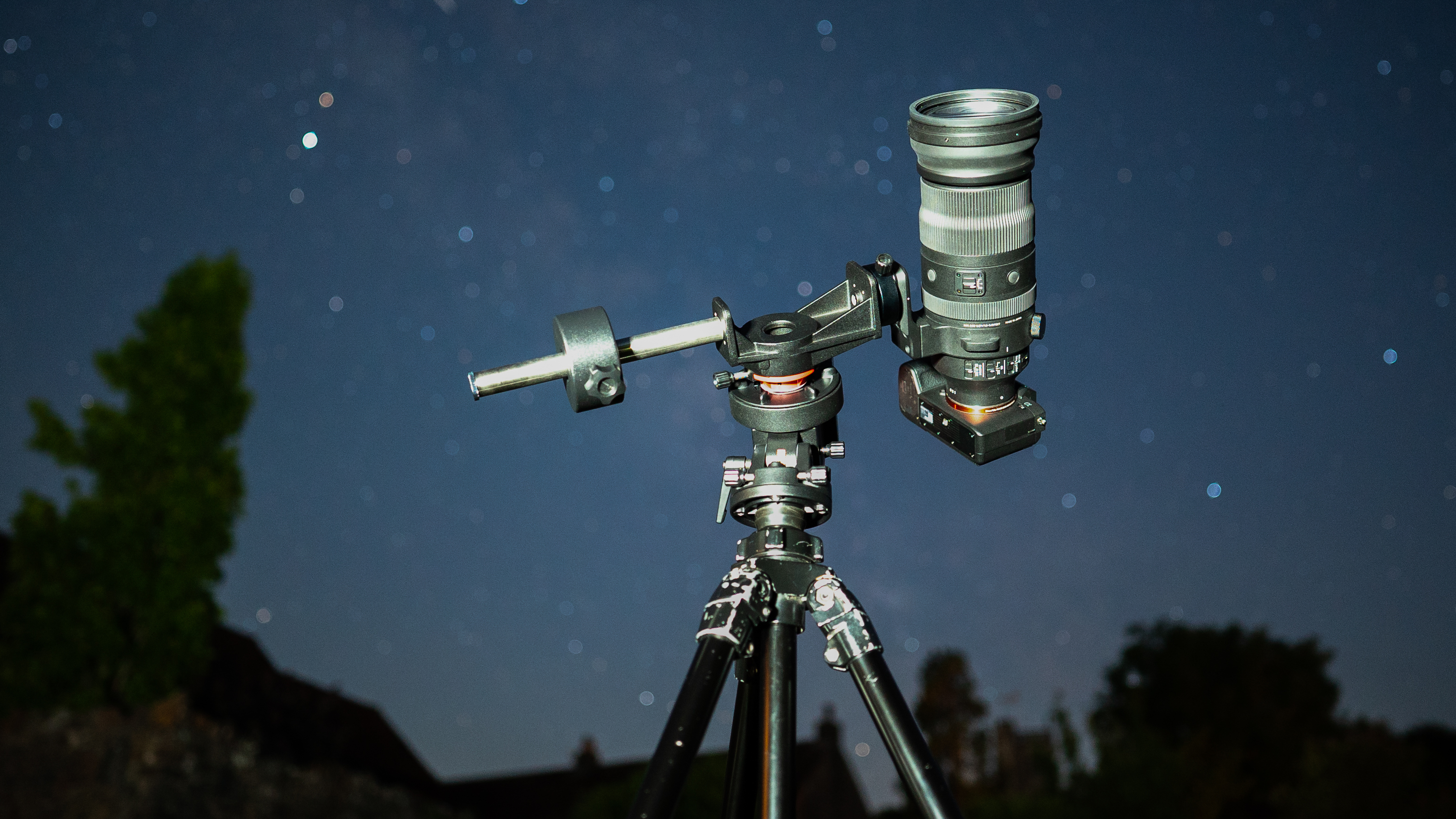 iOptron SkyGuider Pro supporting camera with telephoto zoom outdoors at night under a starry sky