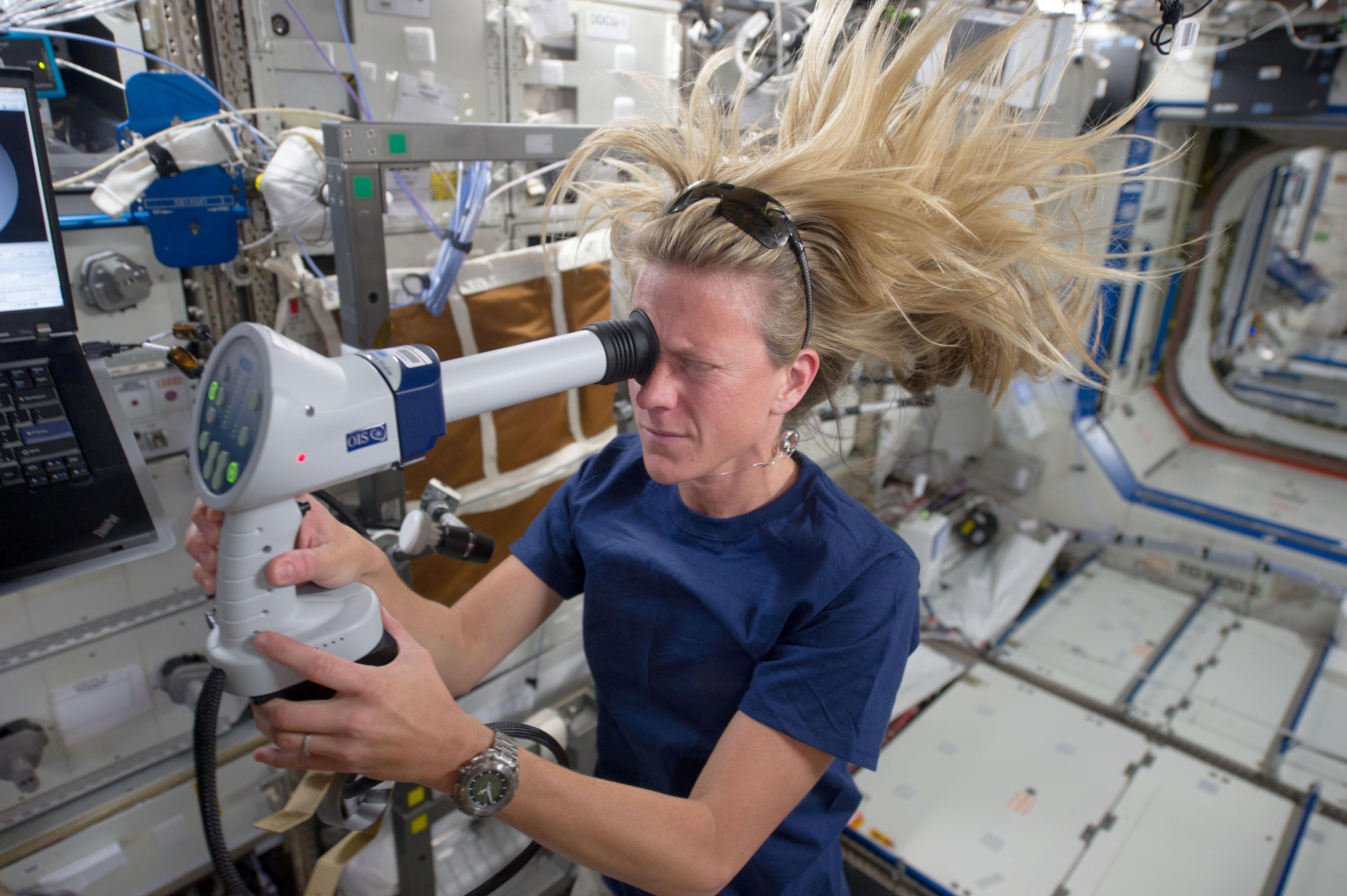 NASA astronaut Karen Nyberg, Expedition 36 flight engineer, conducts an ocular health exam on herself in the Destiny laboratory of the Earth-orbiting International Space Station.