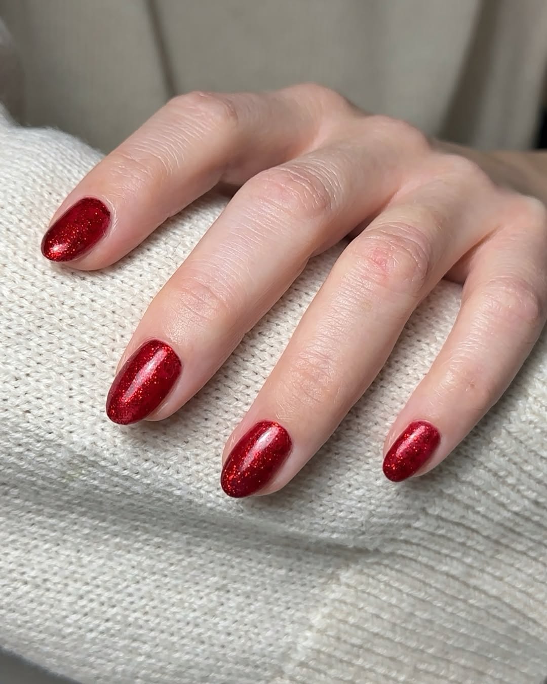 a person wearing sparkly red nail polish