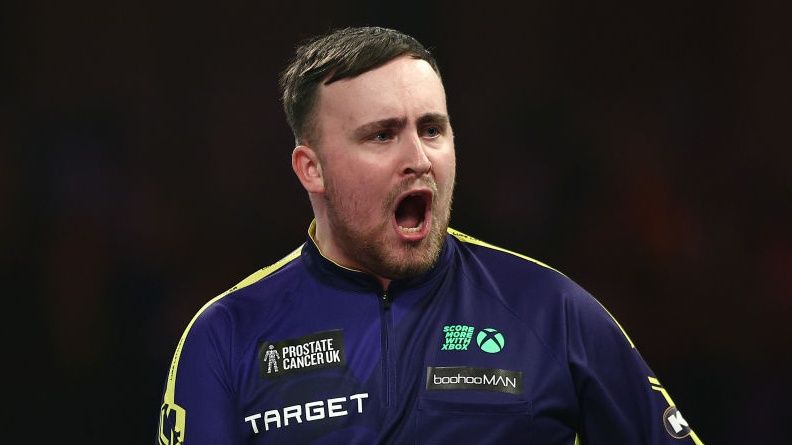 Teenage darts sensation Luke Littler, wearing a purple shirt, roars in celebration ahead of his assault on the Dutch Masters 2025