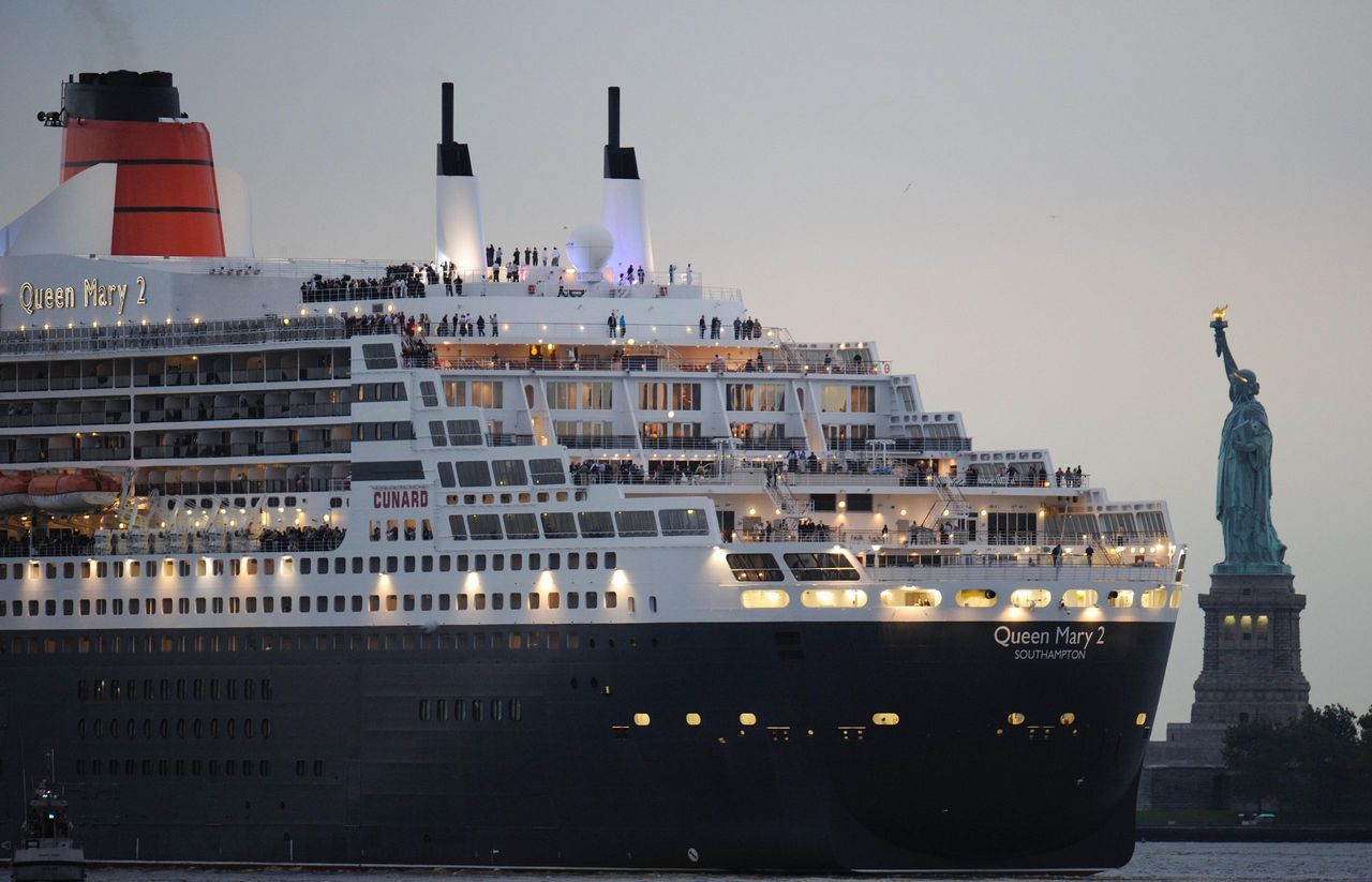 The Queen Mary 2 passes by the Statue of Liberty in New York.