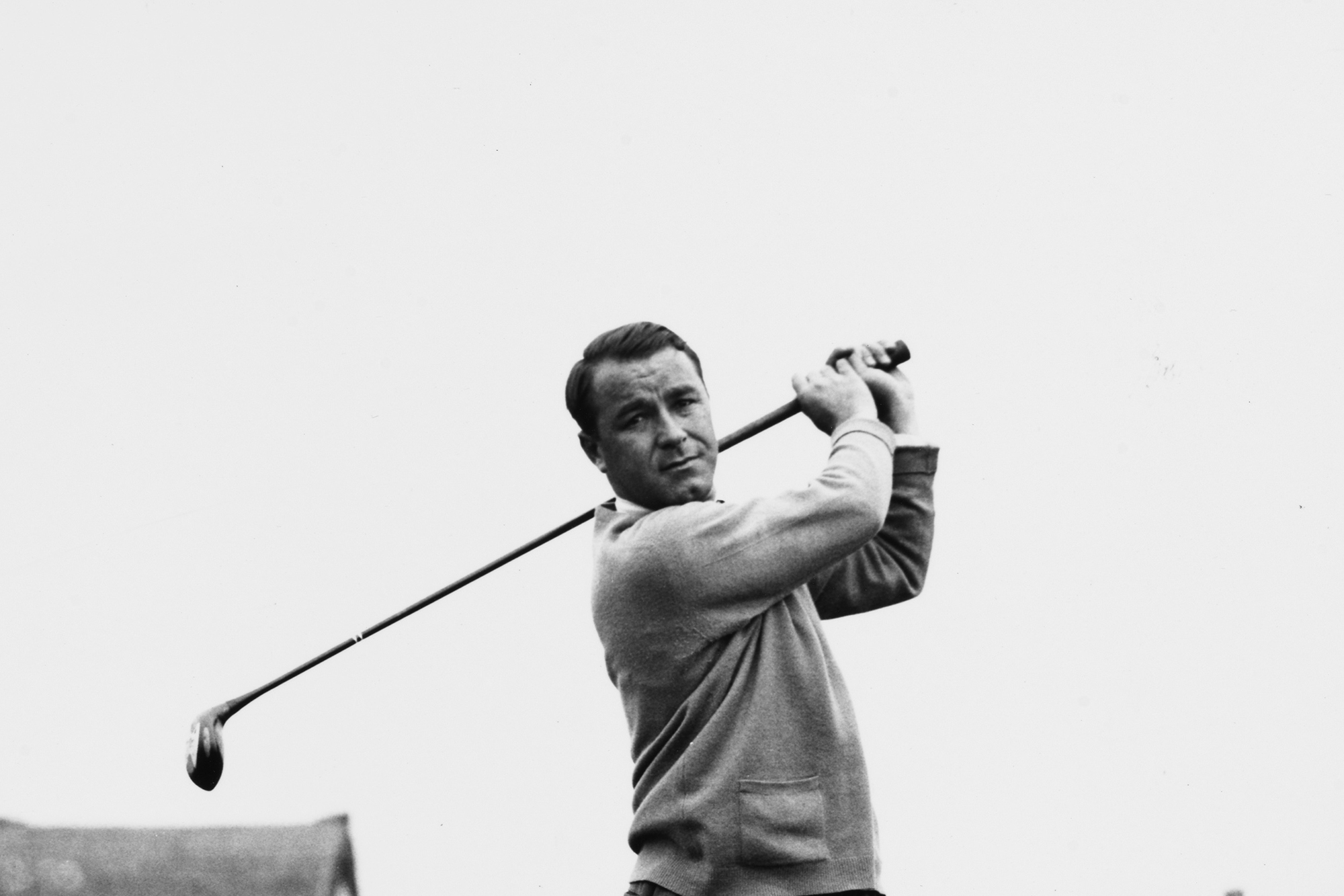 Gene Sarazen at the top of his backswing with a wood watching the ball in flight