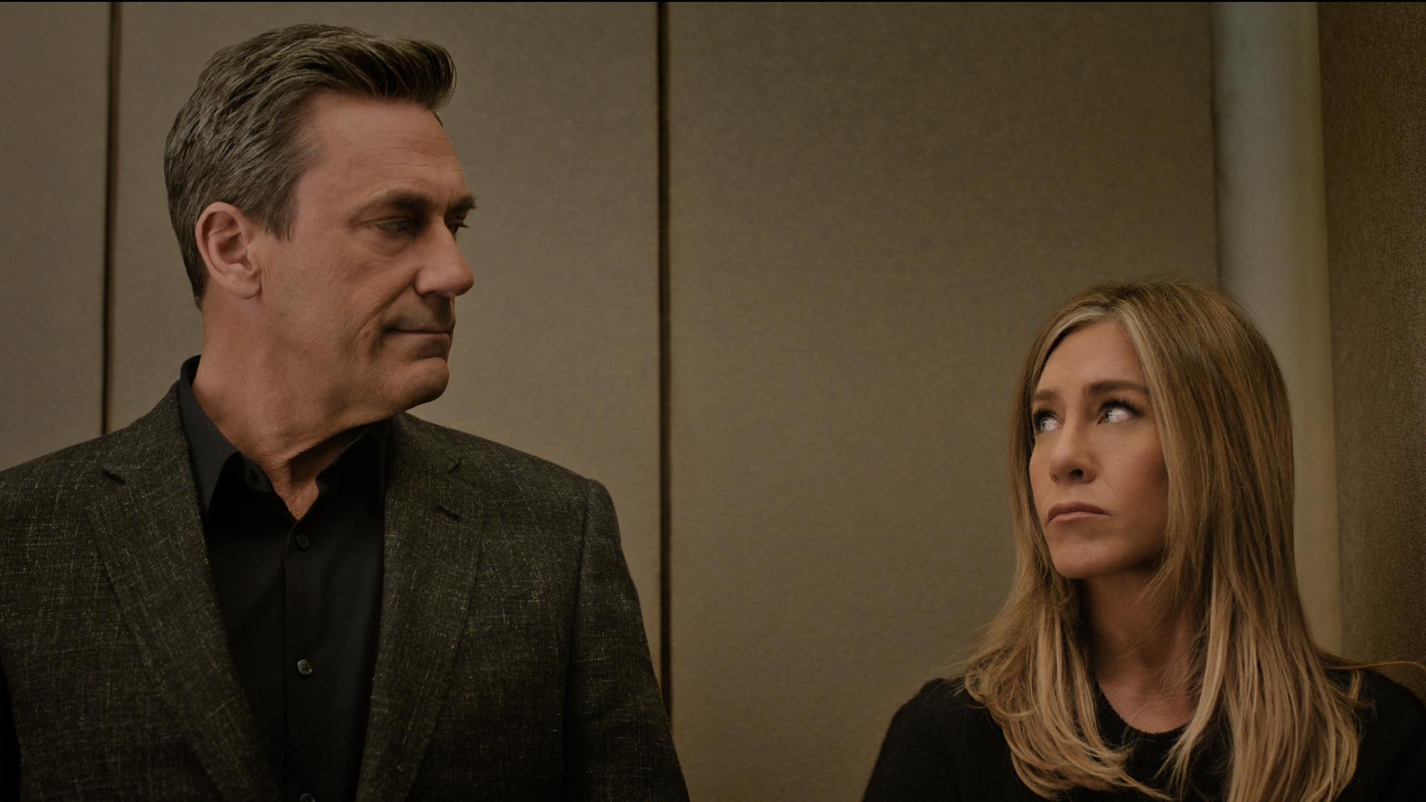 Jon Hamm and Jennifer Aniston looking at each other in The Morning Show