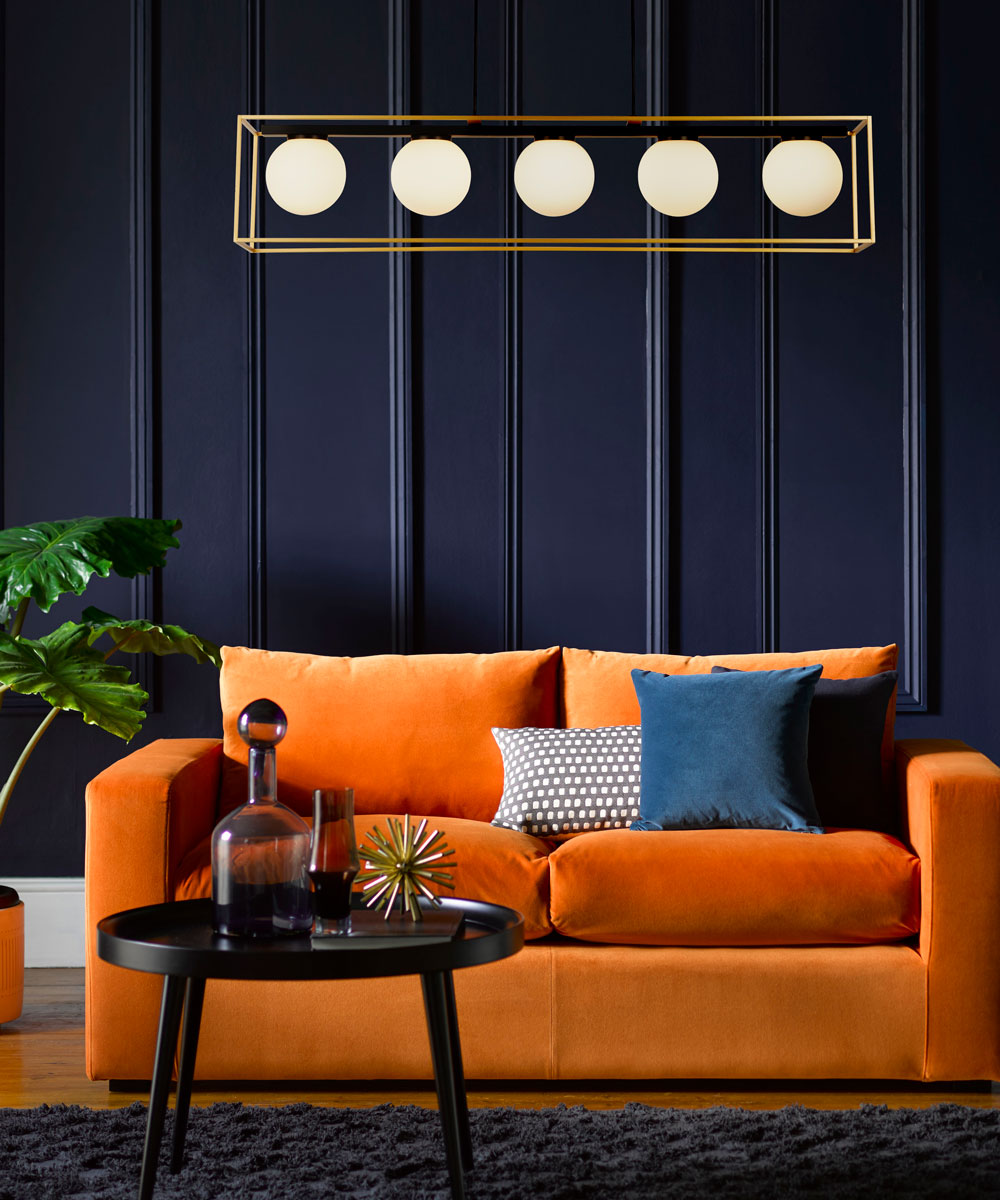 Stella sofa in orange in a blue living room with a 5 light ceiling light