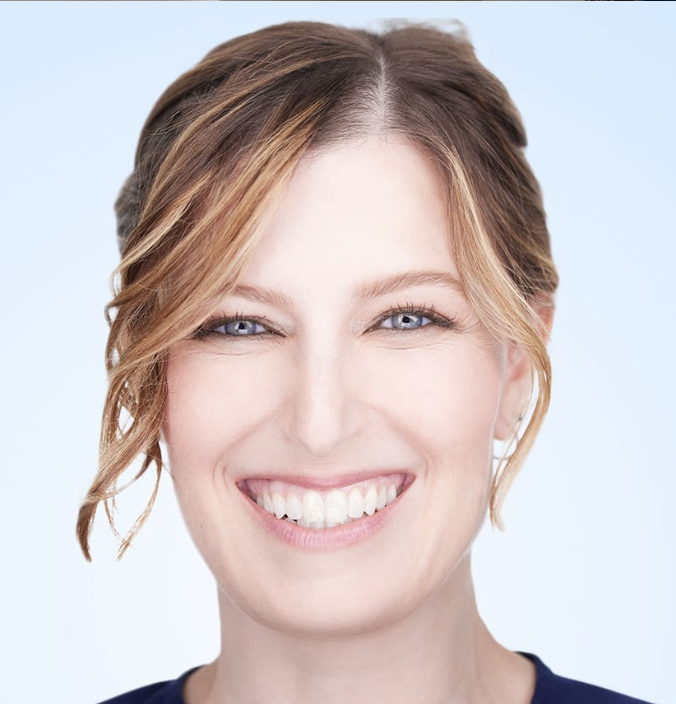 a white woman with reddish blonde hair smiling at the camera