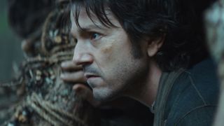 Diego Luna as Cassian Andor looking out from a wall in ANDOR