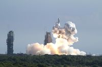 At ignition, flames and smoke from the engines begin liftoff of the Delta 2 Heavy rocket taking NASA's twin Gravity Recovery and Interior Laboratory (GRAIL) mission to the moon from Cape Canaveral Air Force Station in Florida. At left stands the pad's mobile service tower.