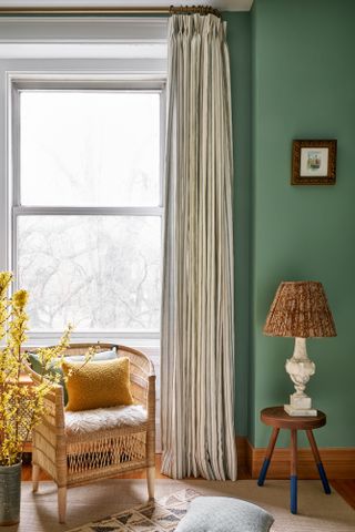 Green living room with striped cream and green curtains