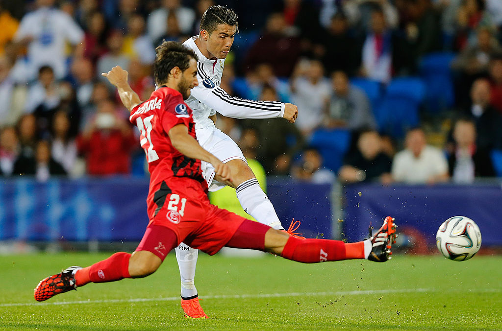 Cristiano Ronaldo del Real Madrid segna il secondo gol della sua squadra sotto la pressione di Nicolas Pareja del Siviglia durante la partita della Supercoppa UEFA tra Real Madrid e Siviglia al Cardiff City Stadium il 12 agosto 2014 a Cardiff, nel Regno Unito.