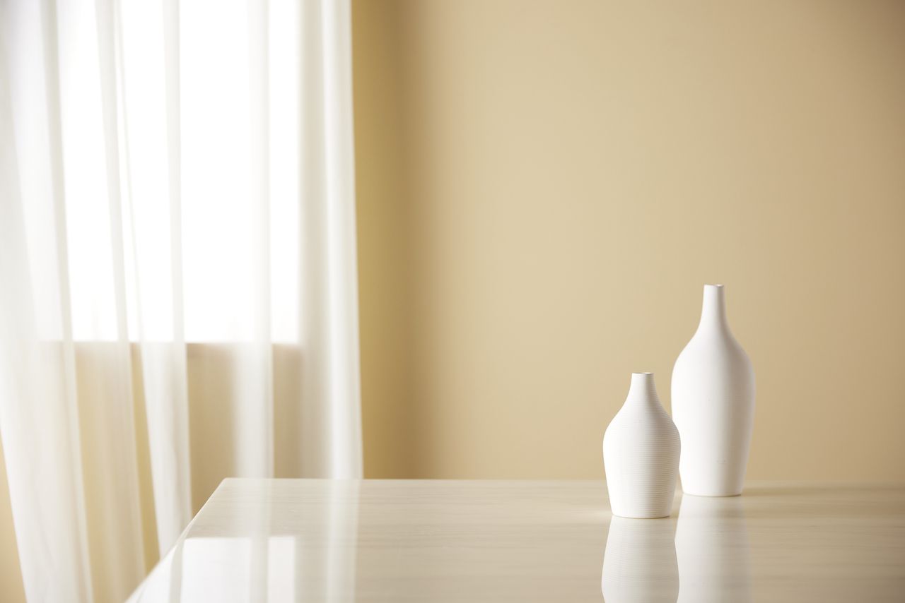 light streaming into a room with vases on table