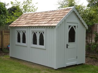 shed with gothic style windows in a soft green