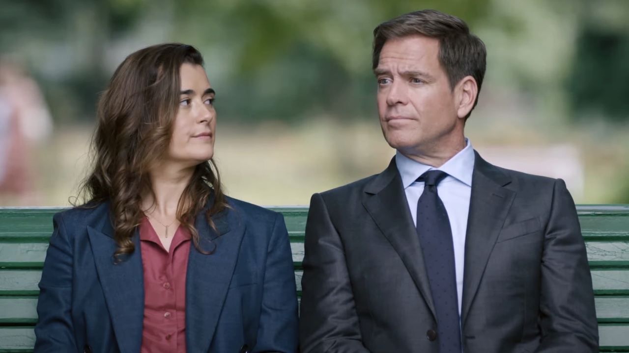 Michael Weatherly and Cote de Pablo seated on bench in NCIS: Tony & Ziva