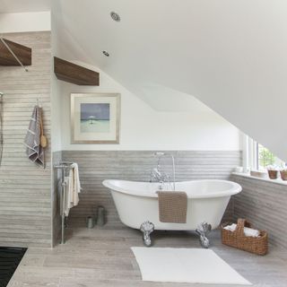 attic bathroom with bathtub and basket