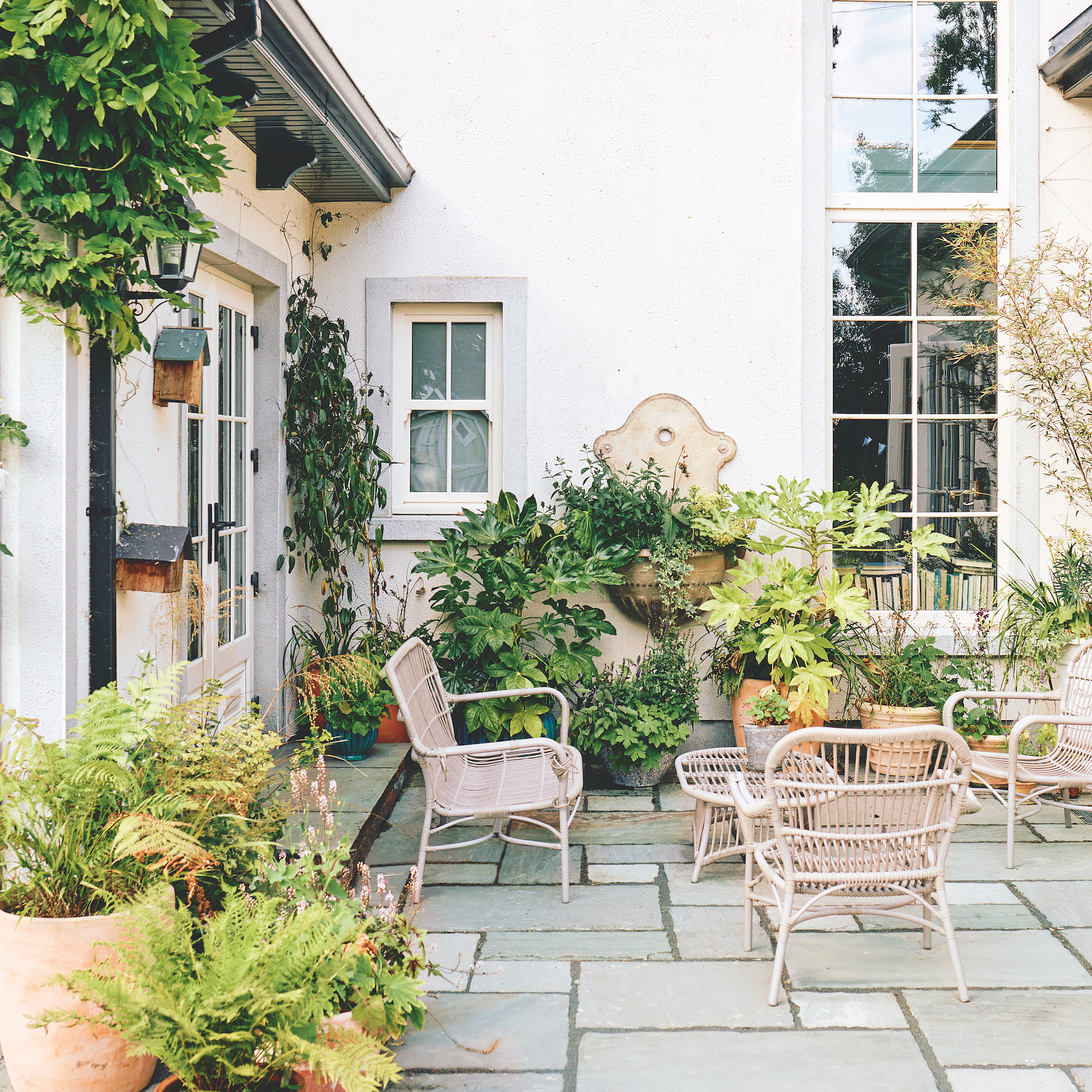 courtyard garden with flagstones, patio furniture and plants in pots