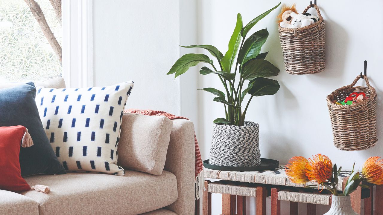 A living room with rattan storage baskets filled with toys hanging on the wall