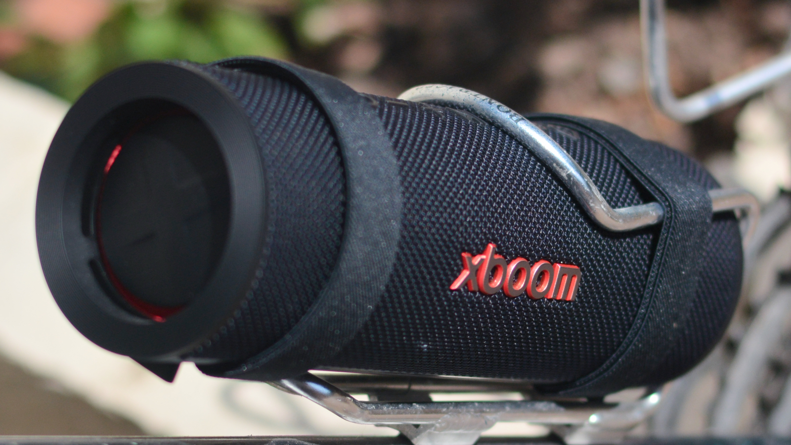 LG xboom Grab Bluetooth speaker in an outdoor setting