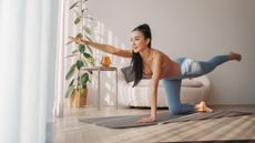 Woman performing the bird dog exercise in a domestic setting