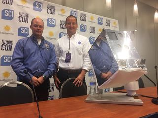 Benjamin Reed, deputy project manager for the Satellite Servicing Capabilities Office at NASA's Goddard Space Flight Center, and Ross Henry, project manager for NASA's Raven module, pose alongside a Raven replica at the Future Con panel, "Robots in Space."