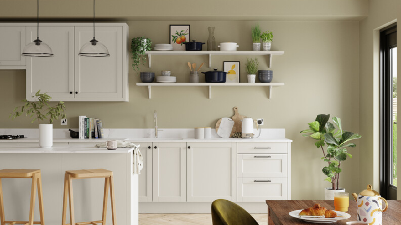 a white kitchen with sage green painted walls and opening shelving 