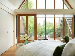 minimalist bedroom with green bedlinen and window