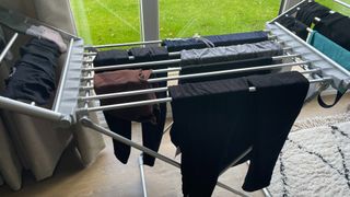 Heated clothes airer being tested with freshly washed laundry placed in front of French doors
