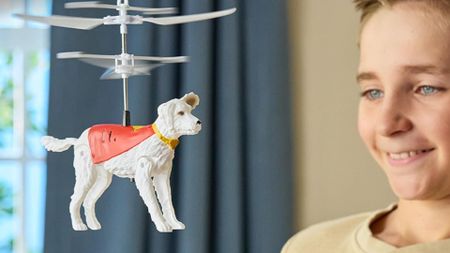 A child smiles at the RC Flying Krypto toy from Superman