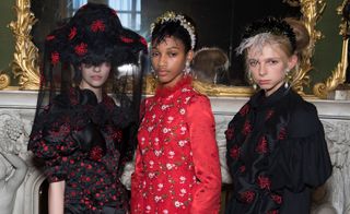 Model wear floral dresses in black and red with hats and headbands
