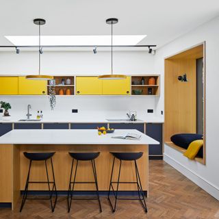 kitchen with island and breakfast bar and stools yellow cabinetry