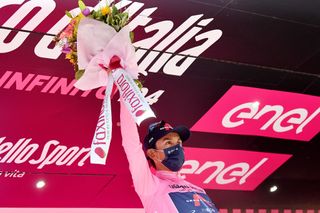 FOLIGNO ITALY MAY 17 Egan Arley Bernal Gomez of Colombia and Team INEOS Grenadiers Pink Leader Jersey celebrates at podium during the 104th Giro dItalia 2021 Stage 10 a 139km stage from LAquila to Foligno Miss Hostess Mask Covid safety measures Trophy Flowers Mascot girodiitalia Giro on May 17 2021 in Foligno Italy Photo by Stuart FranklinGetty Images