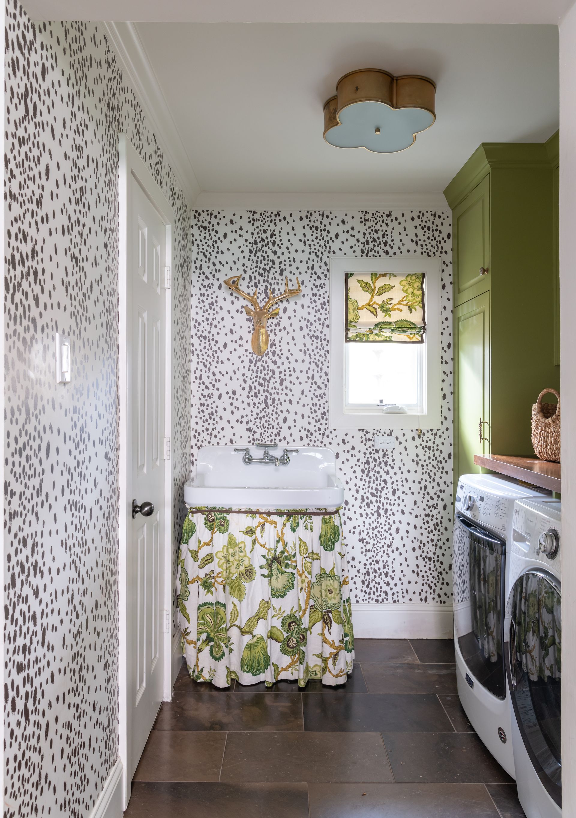 laundry room with black and white animal print wallpaper, green cabinetry, botanical basin curtain, washers, countertop, tiled floor