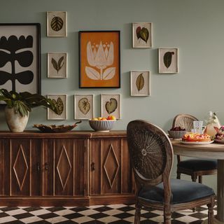 A dining room with a patterned floor and a gallery wall