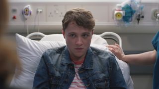 Dominic Sharkey as Ben in a hospital bed with a cut on his head looking like he's in trouble.