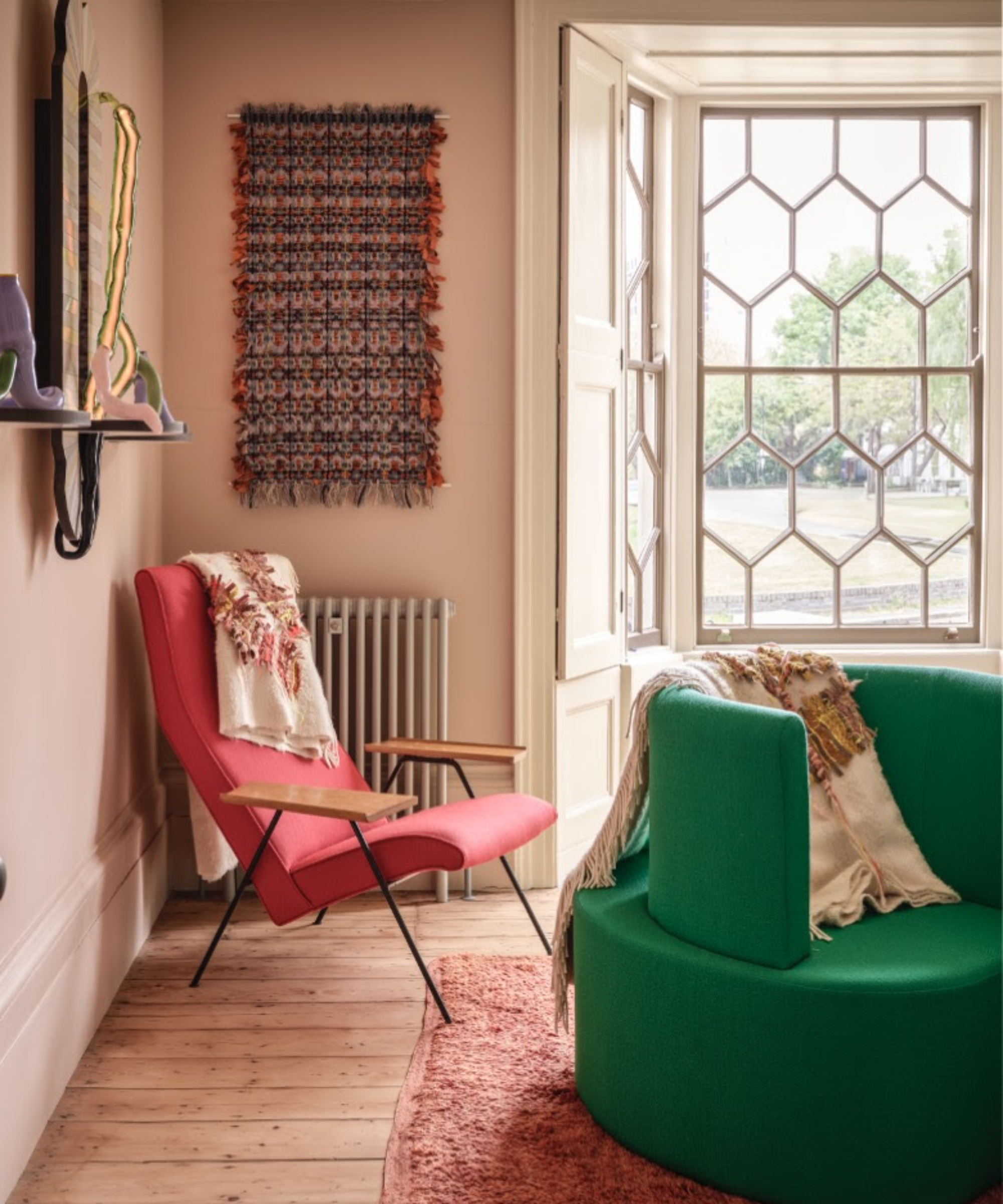 room with light pink walls, bright pink chair and bright green seat