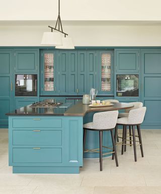 Blue kitchen with asymmetrical kitchen island, bar seating