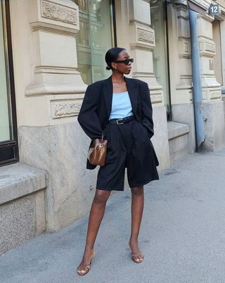 Woman wearing a black blazer and matching long shorts with heels