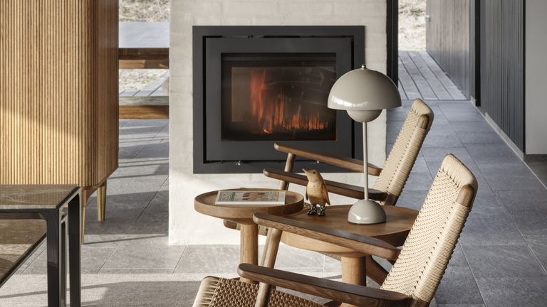 A small living room fireplace idea - a neutral colored midcentury room with a contemporary fireplace to create a dividing wall