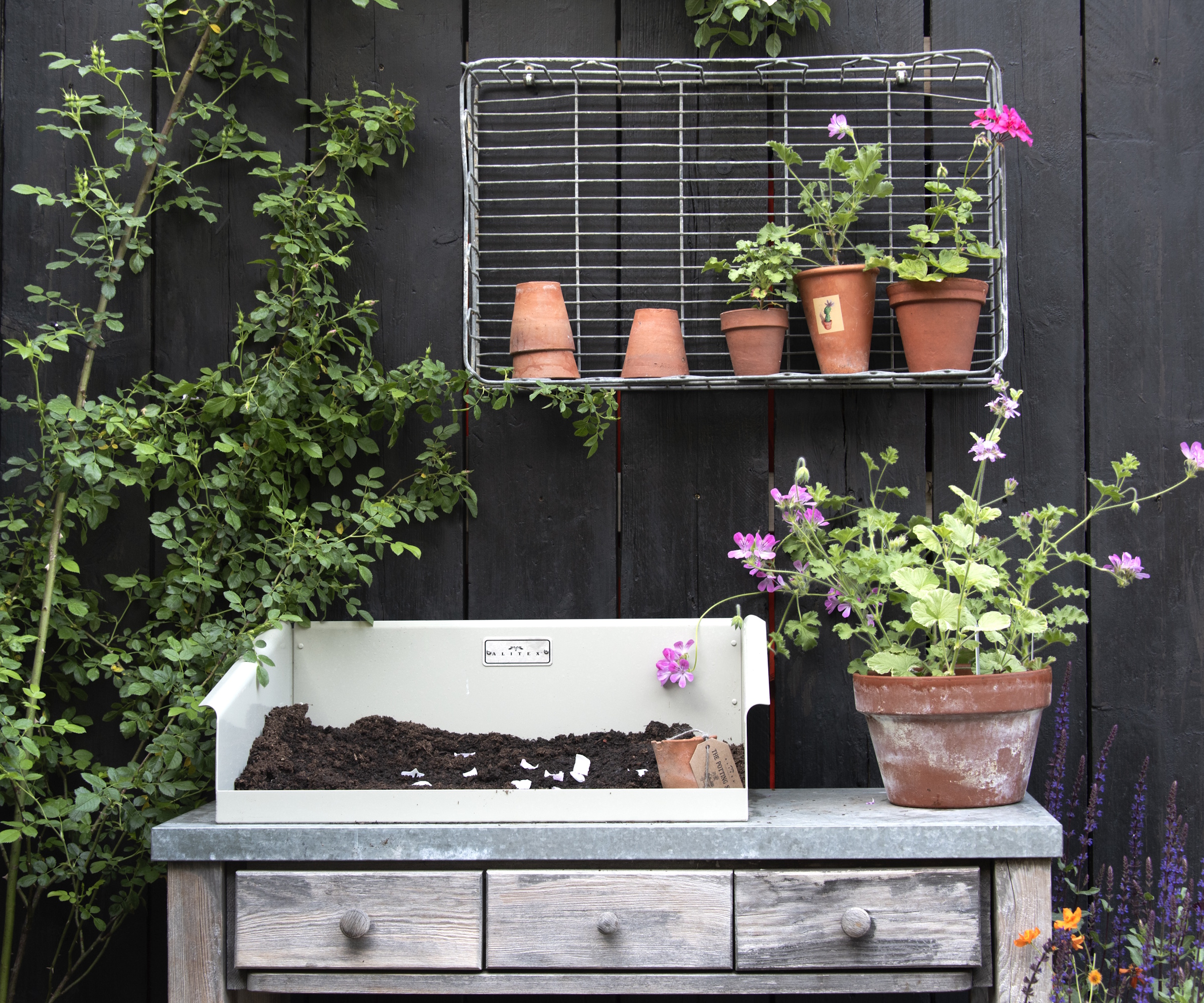 Potting bench against black wooden background with terracotta pots