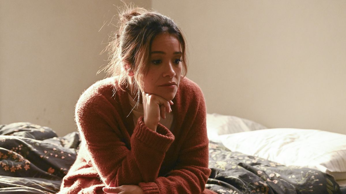 Gina Rodriguez sits on a bed in Not Dead Yet