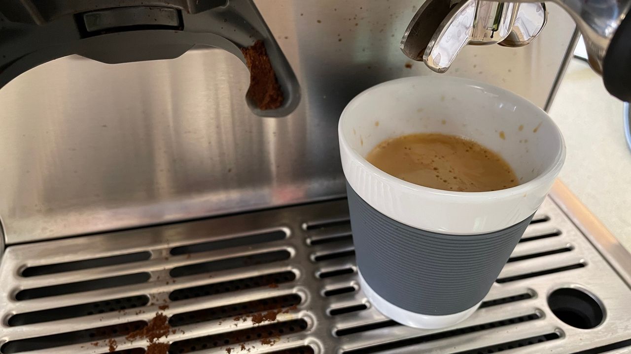 Breville Barista Express coffee maker extracting an espresso with a thick crema