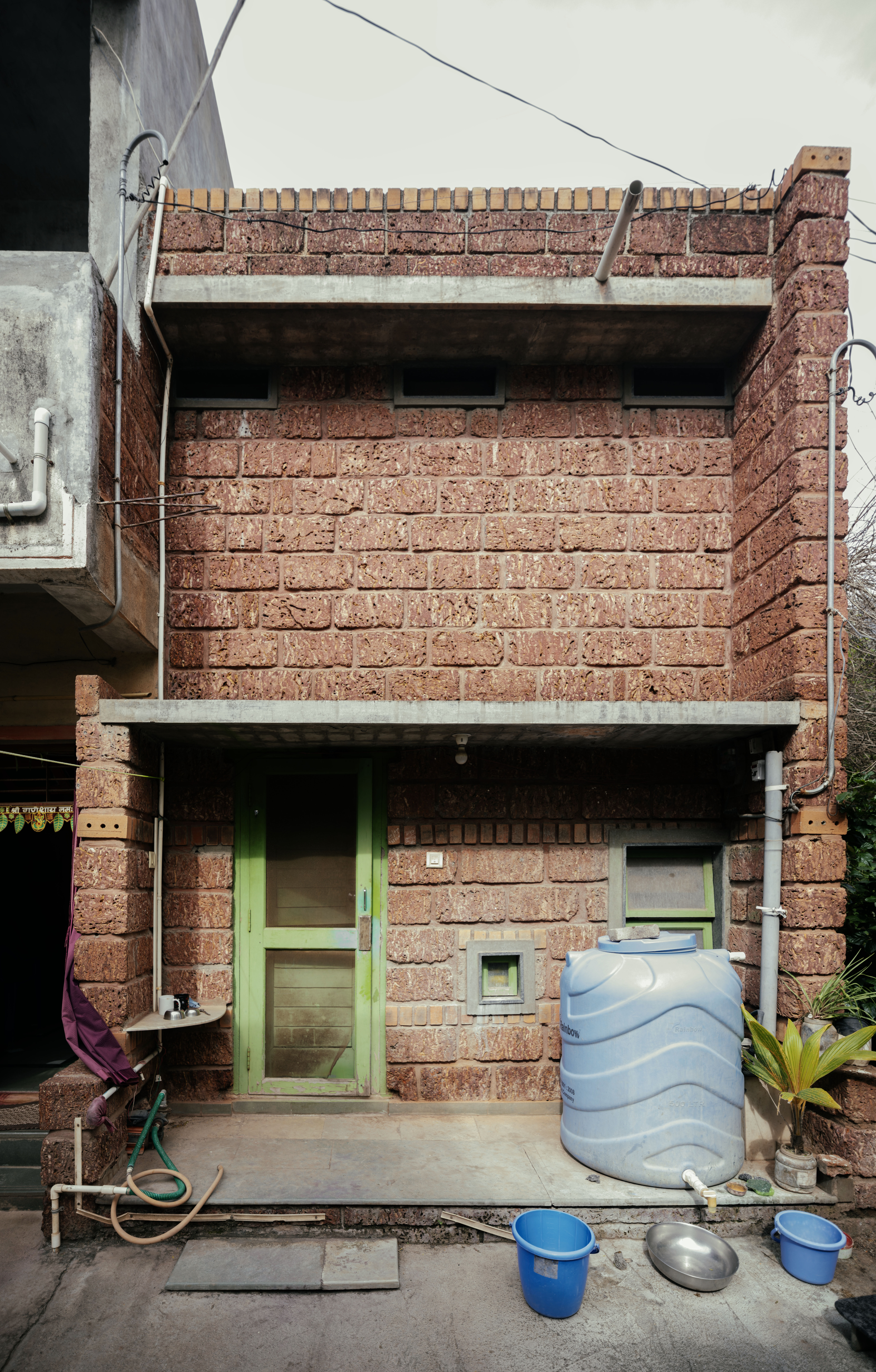 Kanade brothers house in India, brick structure in green surrounds