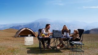 Lifestyle image showing family using a Bluetti power station while camping outdoors