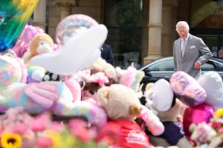 King Charles III reacts as he views the floral and balloon tributes for the victims of the Southport stabbings outside Southport Town Hall during his visit to meet local community and emergency services on August 20, 2024 in Southport, England.