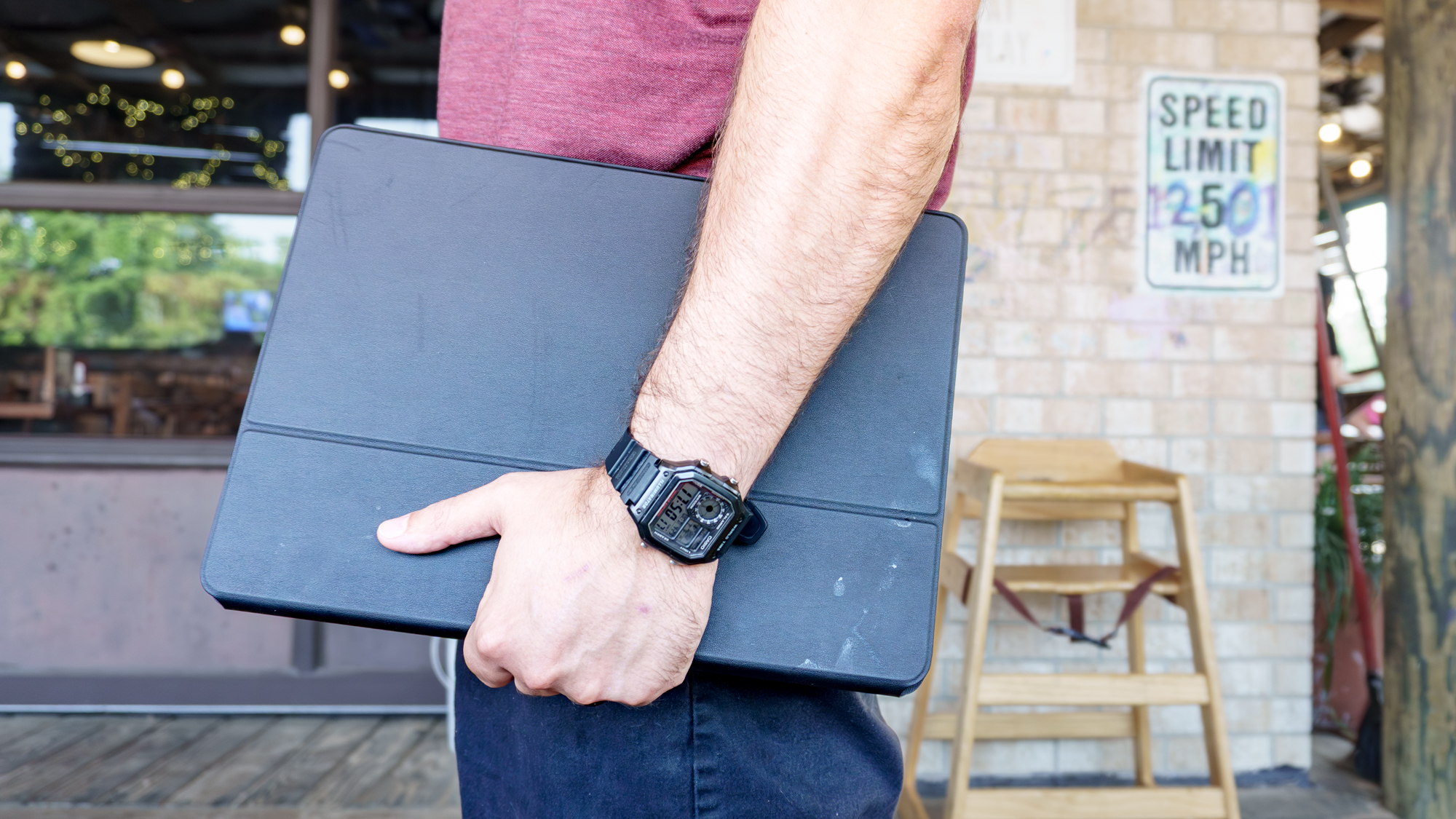 A person carrying the TCL NXTPAPER 14 under their arm at a restauarant
