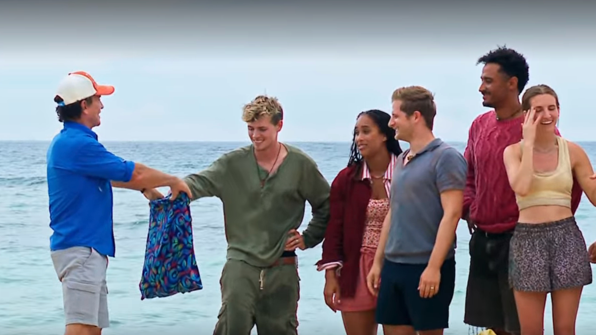 Lewis, Jelly, Mike, Devin and Jenna reach into a bag Jeff is holding to draw buffs on Survivor.